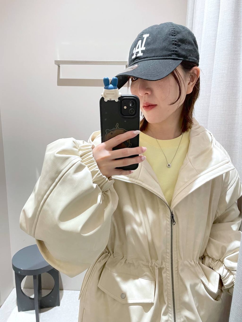 ブラウン系のスカート、ホワイト系のブルゾン、イエロー系のスウェットを着用したレディースの冬コーディネートの6枚目の写真