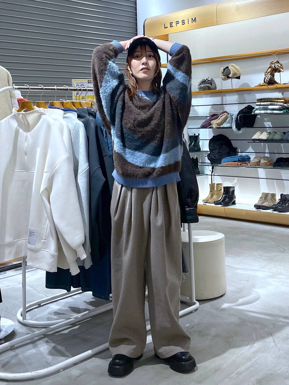 ブラック系のブーツ、ベージュ系のその他パンツ、ブルー系のニット/セーターを着用したレディースの秋コーディネートの3枚目の写真