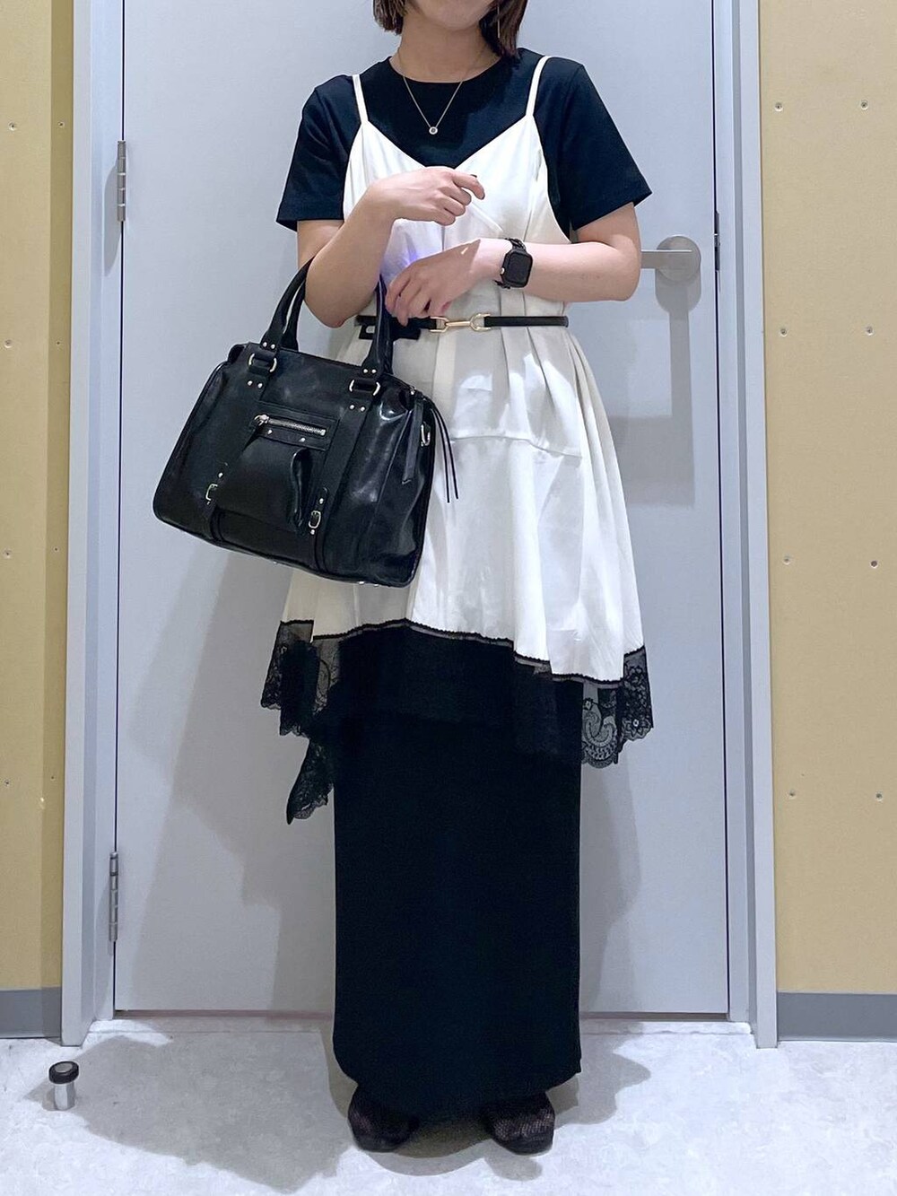 ブラック系のスカート、ブラック系のボストンバッグ、ブラック系のTシャツ/カットソーを着用したレディースの夏コーディネートの2枚目の写真