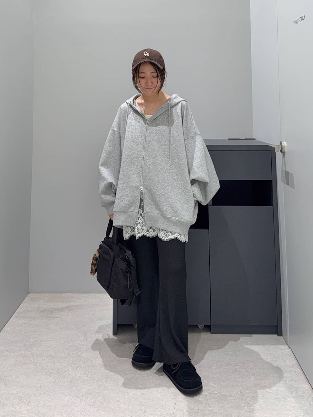 ブラック系のトートバッグ、グレー系のパーカー、ブラック系のその他パンツを着用したレディースの秋コーディネートの2枚目の写真