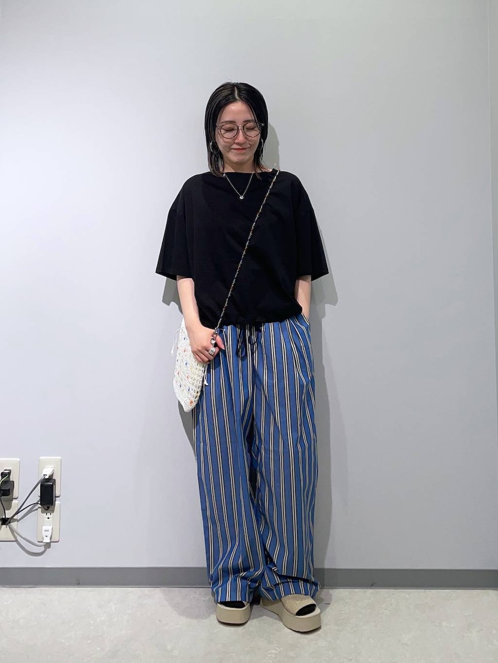 ブルー系のその他パンツ、ホワイト系のサンダル、その他のショルダーバッグを着用したレディースの春コーディネートの2枚目の写真