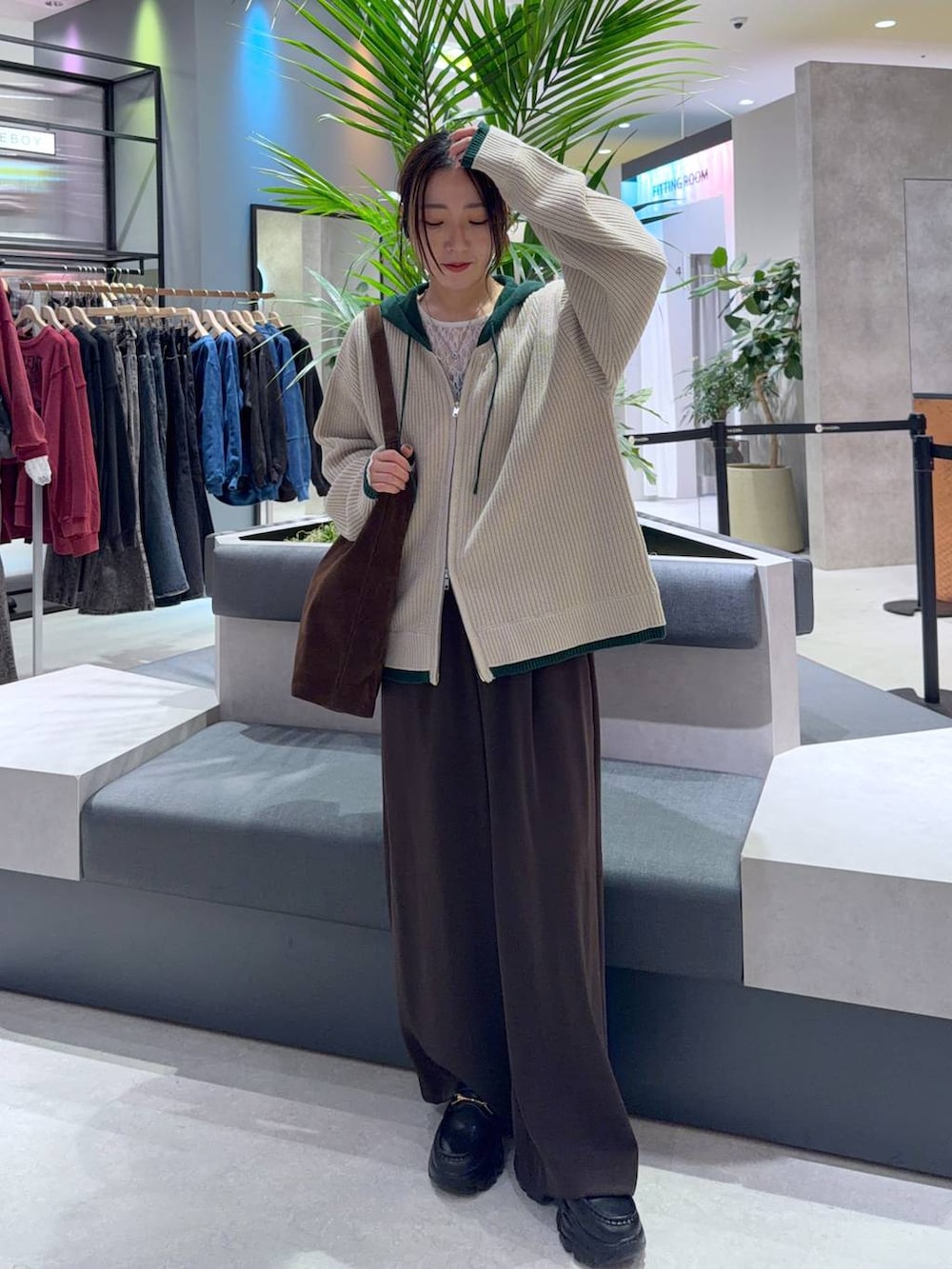 ブラウン系のショルダーバッグ、ブラウン系のスラックス、ホワイト系のTシャツ/カットソーを着用したレディースの秋コーディネートの2枚目の写真