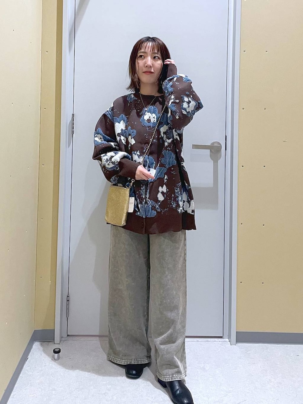 ゴールド系のショルダーバッグ、ブラウン系のカーディガン/ボレロ、グレー系のスウェットパンツを着用したレディースの秋コーディネートの2枚目の写真