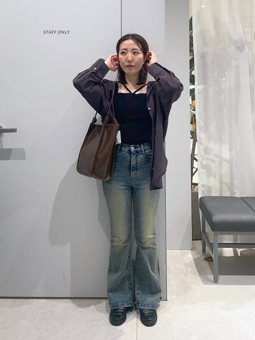 ブルー系のデニムパンツ、ブラウン系のトートバッグ、グレー系のシャツ/ブラウスを着用したレディースの春コーディネートの2枚目の写真