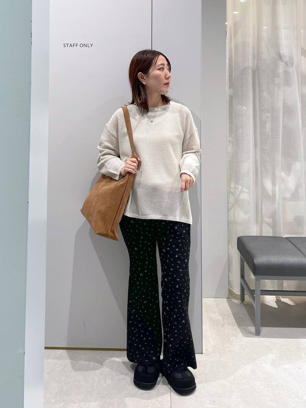 ベージュ系のショルダーバッグ、ホワイト系のニット/セーター、ブラック系のその他パンツを着用したレディースの春コーディネートの3枚目の写真