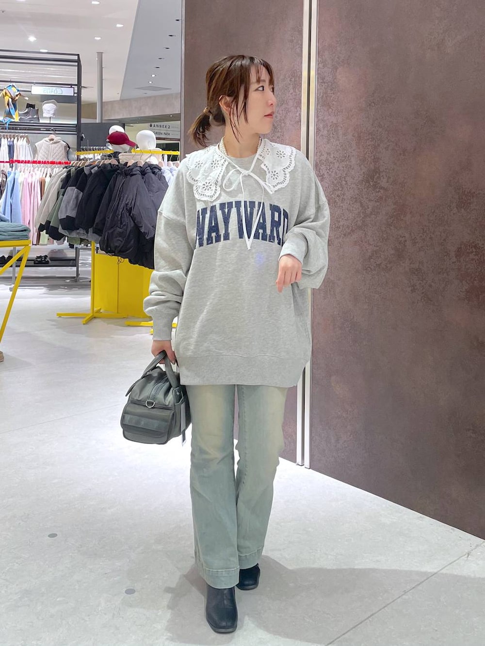 グリーン系のボストンバッグ、グレー系のスウェットを着用したレディースの冬コーディネートの4枚目の写真
