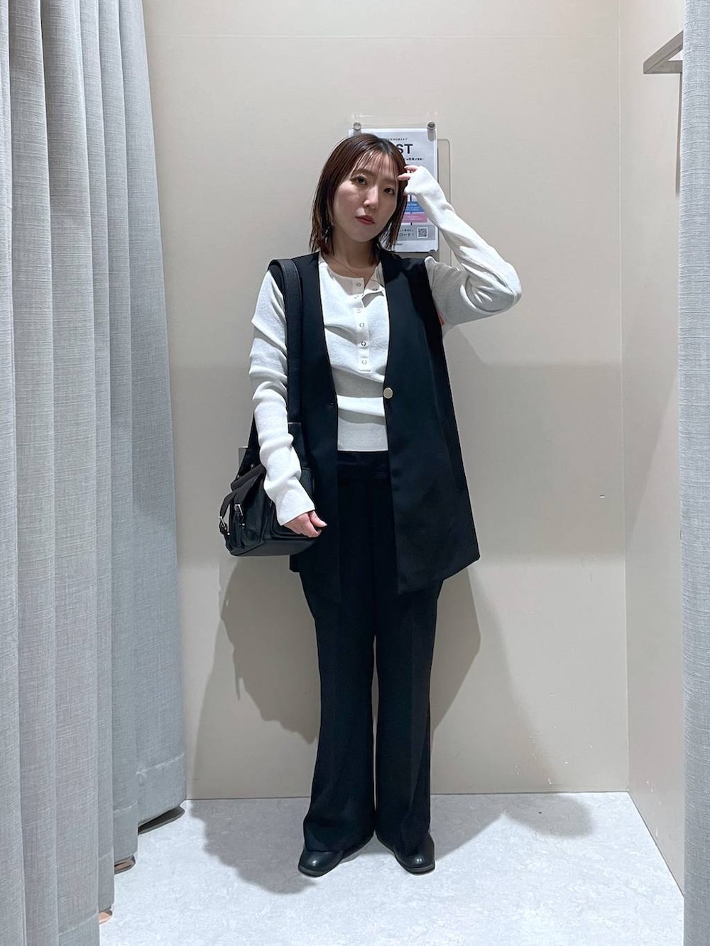 ブラック系のその他アウター、ホワイト系のニット/セーター、ブラック系のショルダーバッグを着用したレディースの冬コーディネートの4枚目の写真