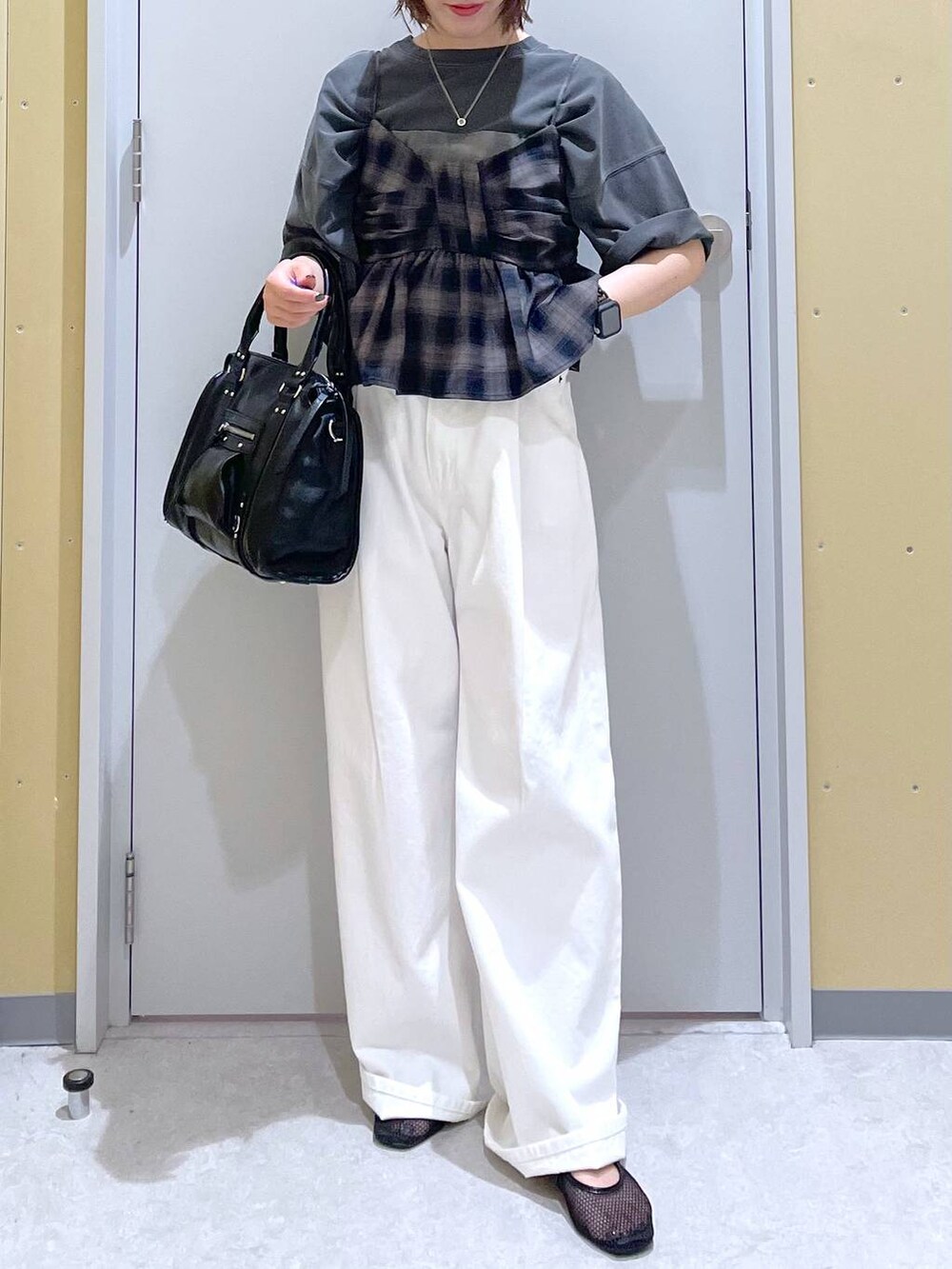 ホワイト系のデニムパンツ、ブラック系のボストンバッグ、グレー系のTシャツ/カットソーを着用したレディースの夏コーディネートの4枚目の写真