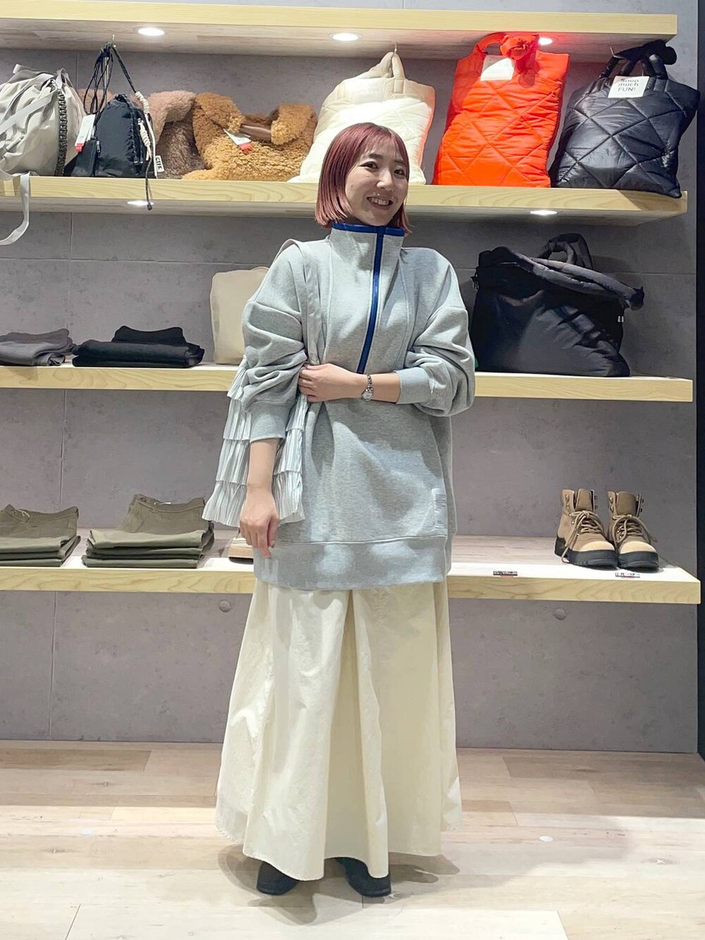 グレー系のTシャツ/カットソー、シルバー系のトートバッグ、ホワイト系のスカートを着用したレディースの冬コーディネートの2枚目の写真