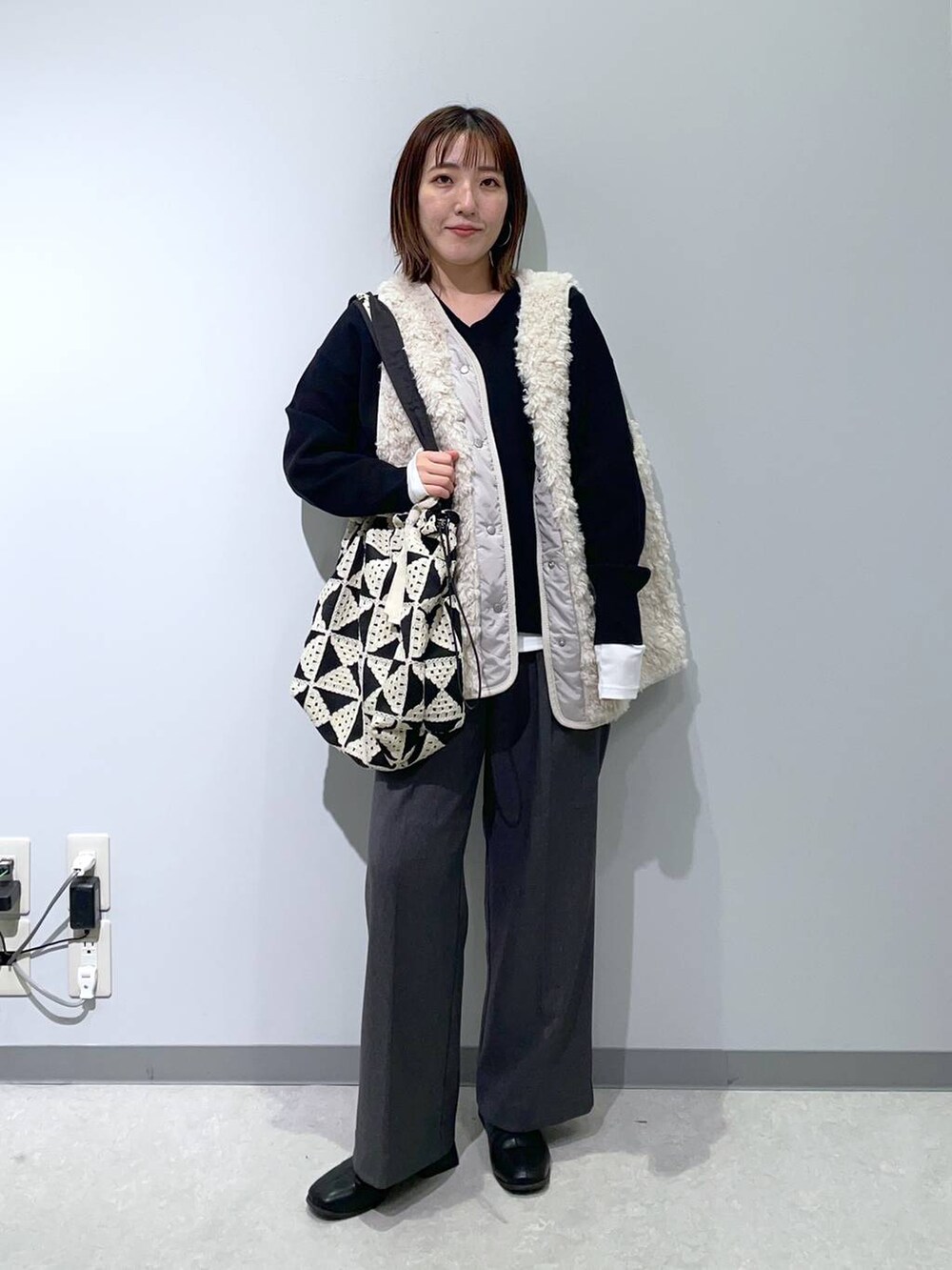 ホワイト系のTシャツ/カットソー、ベージュ系のベスト、ブラック系のスウェットを着用したレディースの秋コーディネートの3枚目の写真