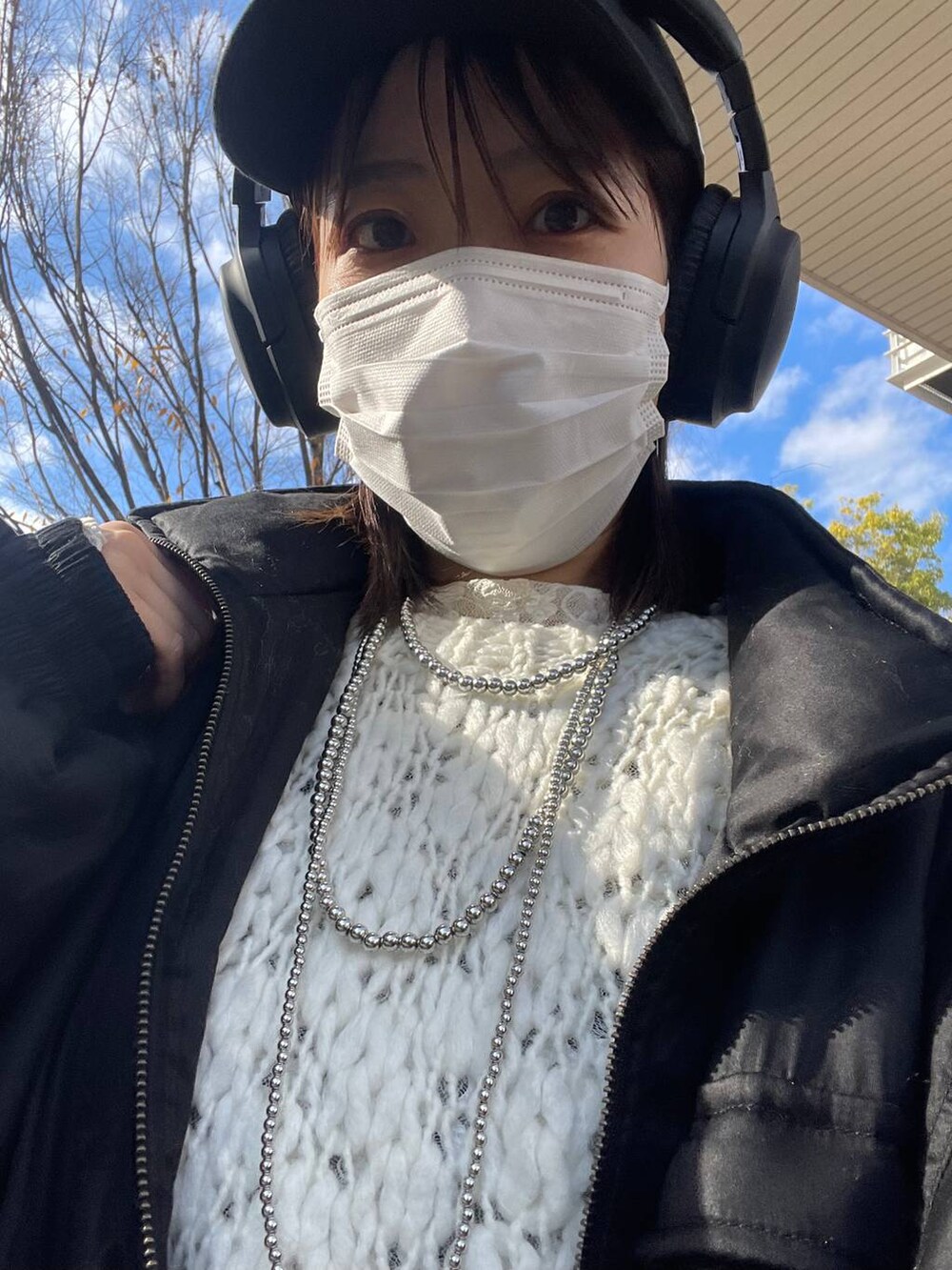 グレー系のスラックス、ブラック系のブルゾン、ホワイト系のニット/セーターを着用したレディースの冬コーディネートの4枚目の写真