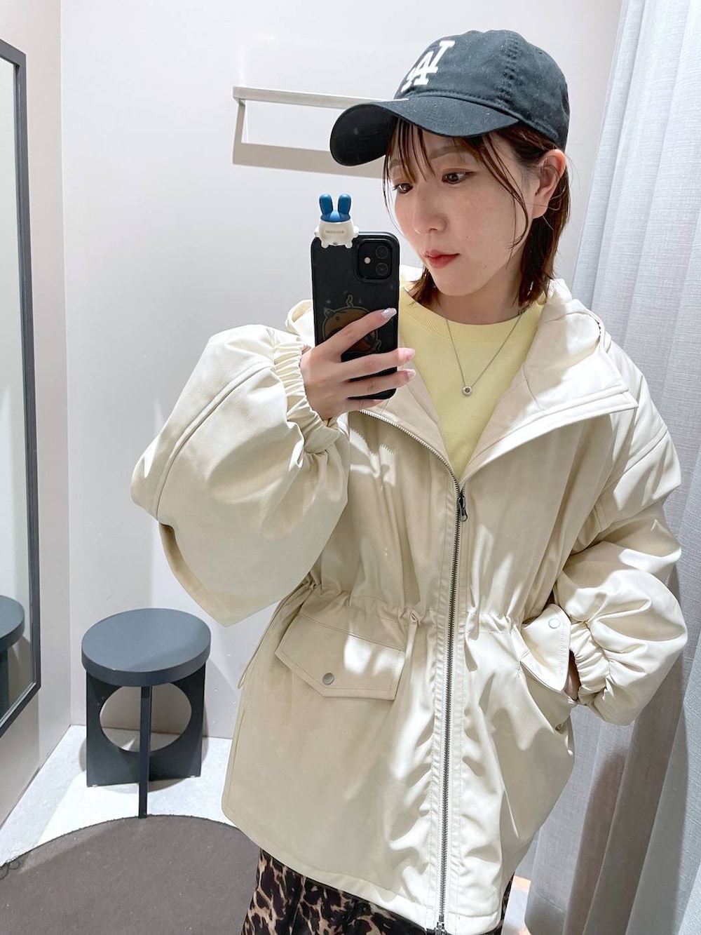 ブラウン系のスカート、ホワイト系のブルゾン、イエロー系のスウェットを着用したレディースの冬コーディネートの2枚目の写真