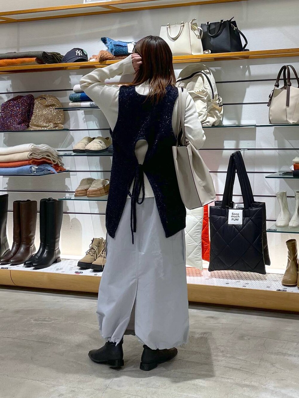 ホワイト系のニット/セーター、グレー系のスカート、ベージュ系のトートバッグを着用したレディースの冬コーディネートの3枚目の写真