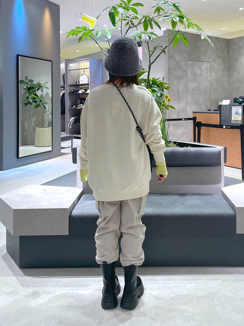 ブラック系のショルダーバッグ、ブラック系のブーツ、ベージュ系のカーゴパンツを着用したレディースの冬コーディネートの3枚目の写真