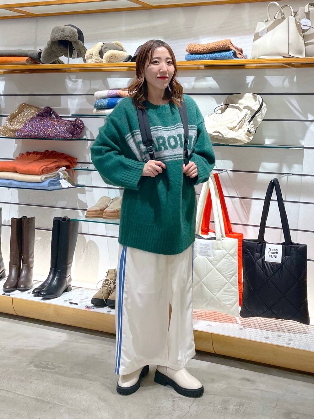 ホワイト系のブーツ、ブラック系のバックパック/リュック、ホワイト系のスカートを着用したレディースの冬コーディネートの2枚目の写真