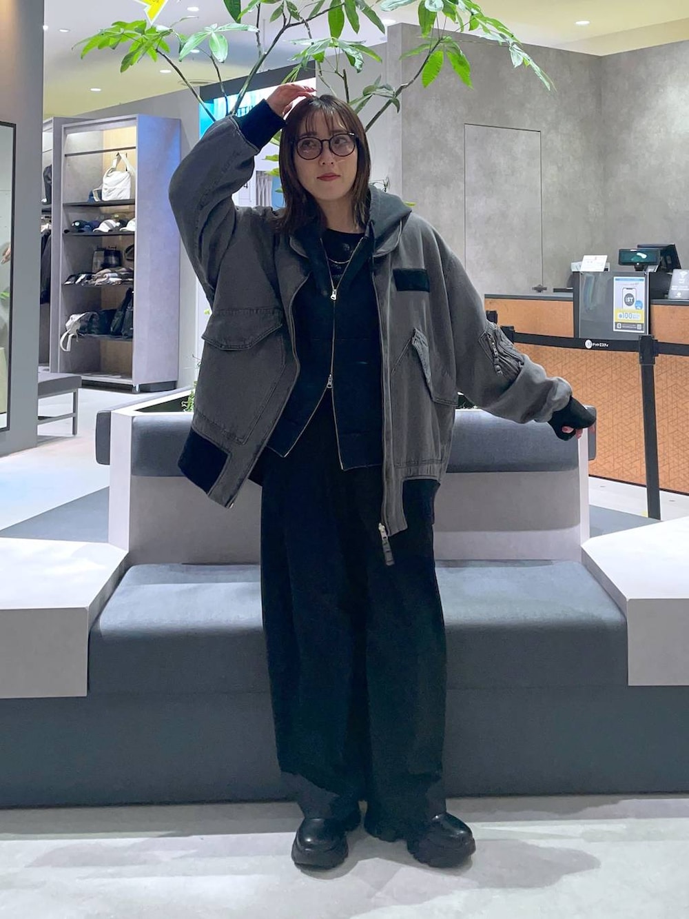 グレー系のブルゾン、ブラック系のスラックス、ブラック系のTシャツ/カットソーを着用したレディースの冬コーディネートの4枚目の写真