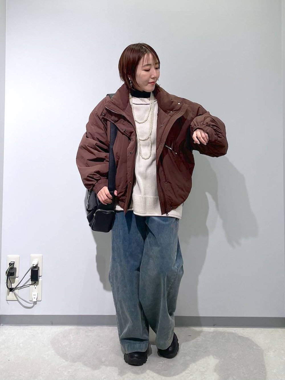 ブラウン系のその他アウター、ブラック系のニット/セーター、ブルー系のその他パンツを着用したレディースの冬コーディネートの5枚目の写真