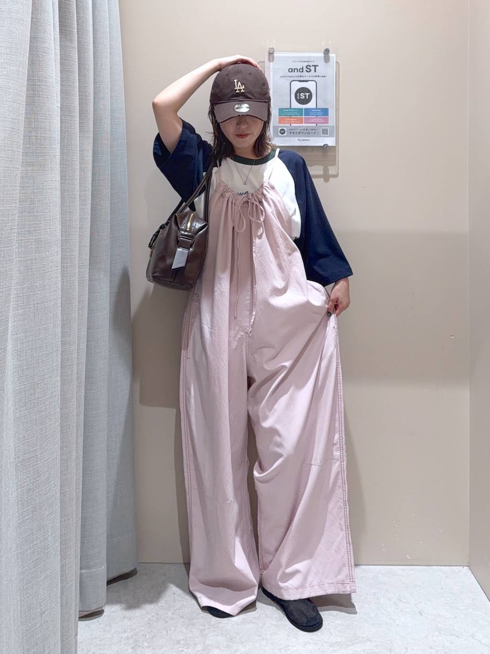 ブラウン系のボストンバッグ、ピンク系のサロペット/オーバーオール、ブルー系のTシャツ/カットソーを着用したレディースの夏コーディネートの2枚目の写真