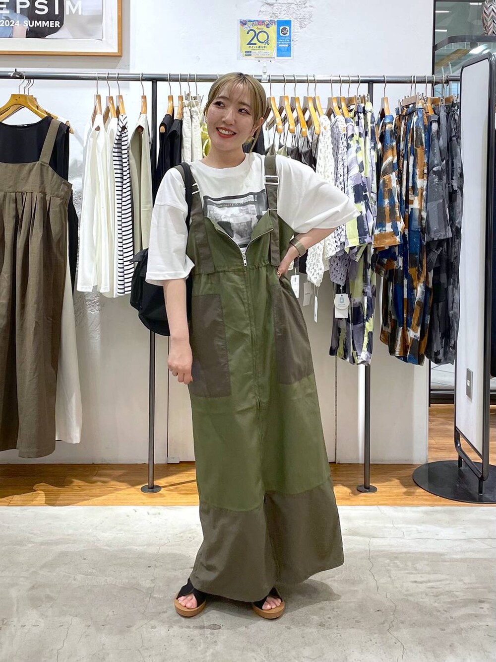 ブラック系のショルダーバッグ、ブラック系のサンダル、ホワイト系のTシャツ/カットソーを着用したレディースの夏コーディネートの2枚目の写真