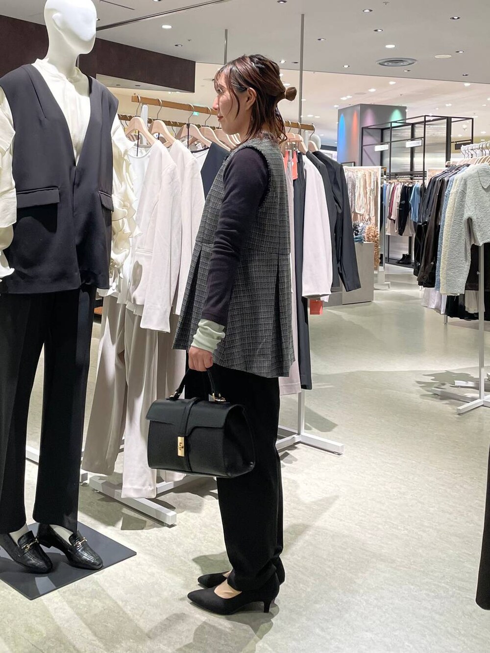 ブラック系のその他パンツ、ブラック系のベスト、ブラック系のショルダーバッグを着用したレディースの冬コーディネートの2枚目の写真