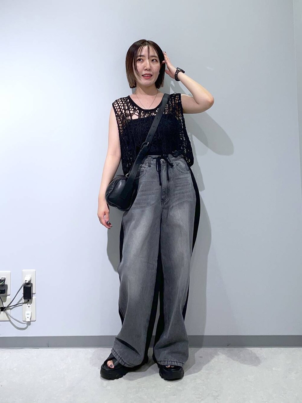 ブラック系のベスト、ブラック系のサンダル、ブラック系のショルダーバッグを着用したレディースの夏コーディネートの3枚目の写真