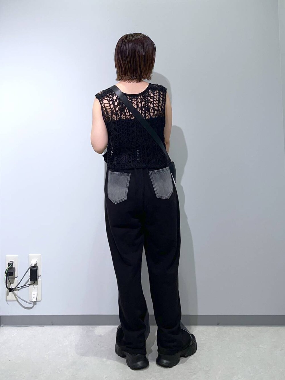 ブラック系のベスト、ブラック系のサンダル、ブラック系のショルダーバッグを着用したレディースの夏コーディネートの2枚目の写真