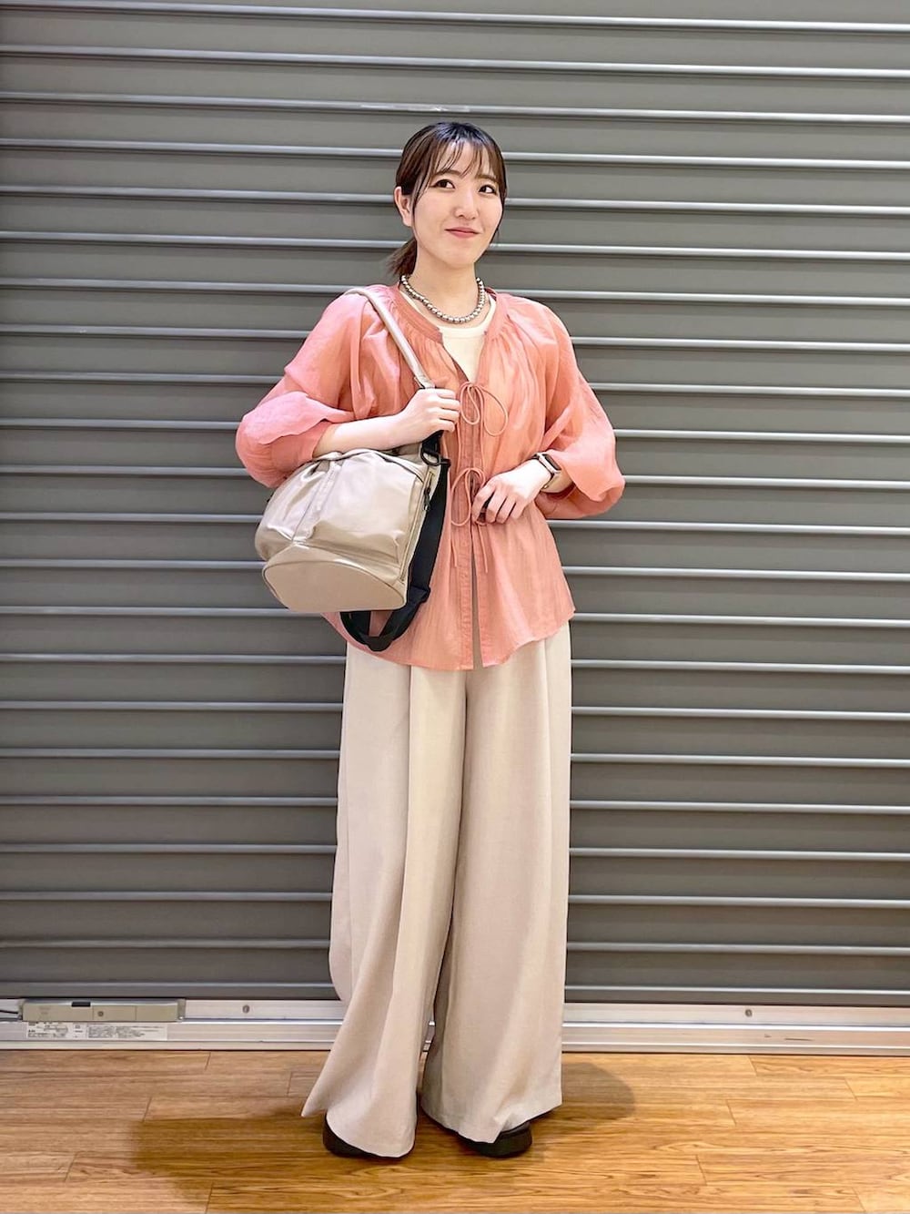 ピンク系のシャツ/ブラウス、ベージュ系のその他パンツ、ホワイト系のタンクトップを着用したレディースの春コーディネートの2枚目の写真