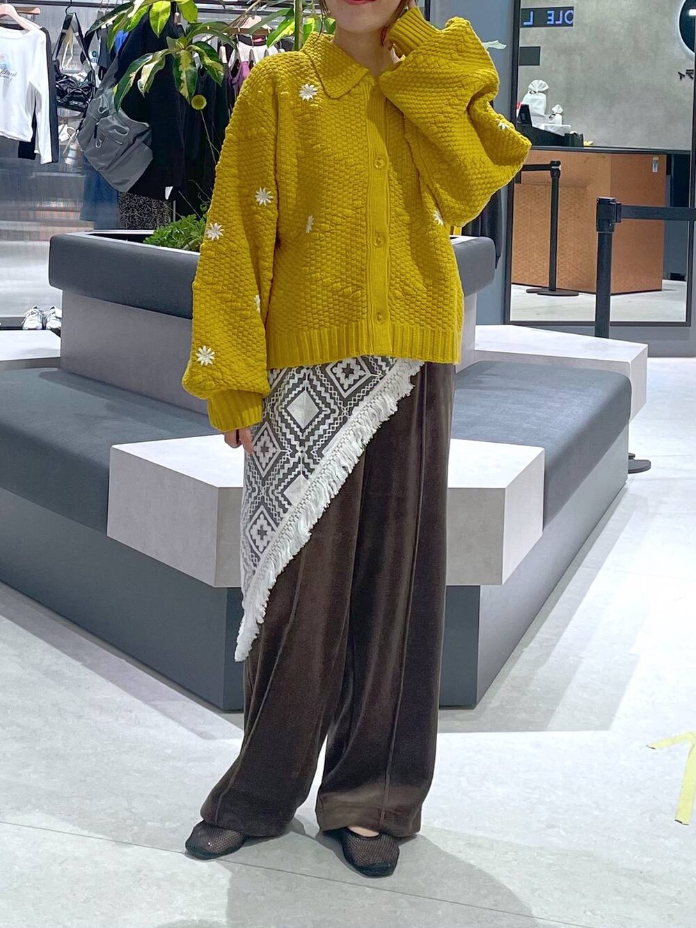 ブラウン系のその他パンツ、イエロー系のカーディガン/ボレロ、ホワイト系のバンダナ/スカーフを着用したレディースの秋コーディネートの3枚目の写真