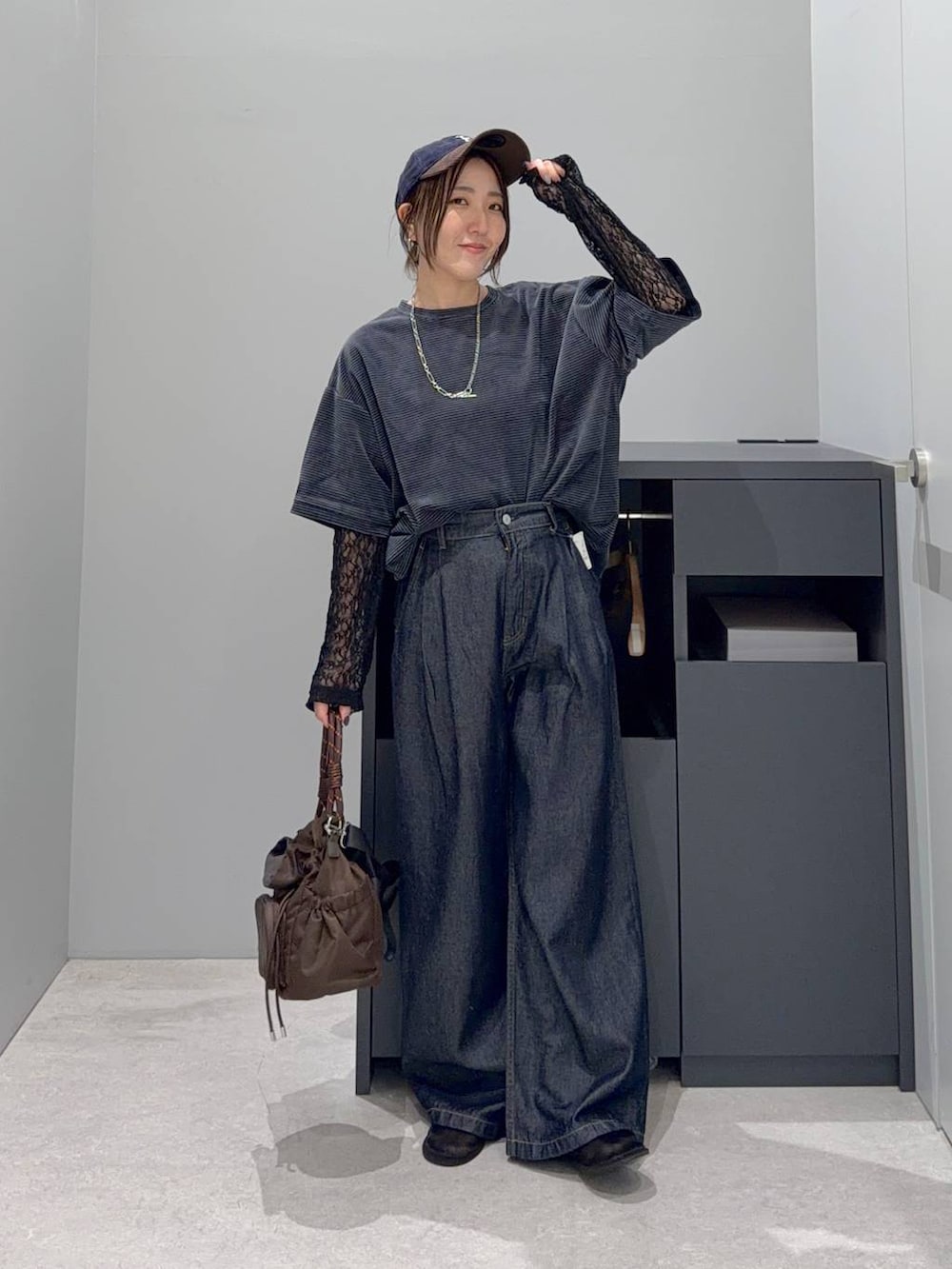 グリーン系のTシャツ/カットソー、ブラウン系のショルダーバッグ、ブルー系のデニムパンツを着用したレディースの夏コーディネートの2枚目の写真