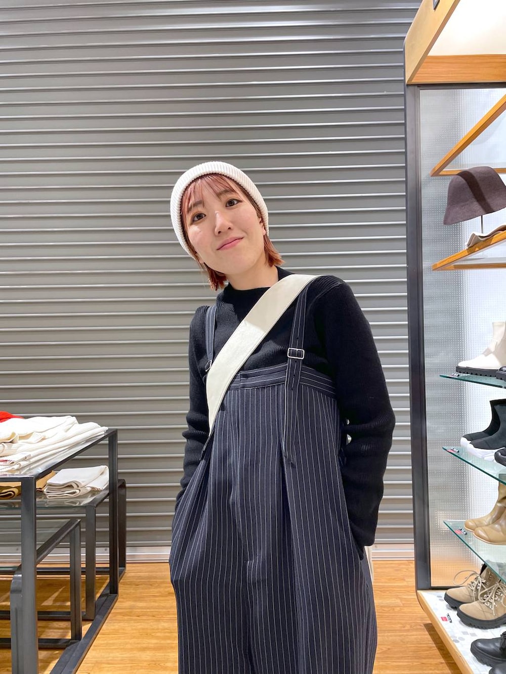 ブラック系のニット/セーター、ホワイト系のショルダーバッグ、ブルー系のその他パンツを着用したレディースの冬コーディネートの5枚目の写真