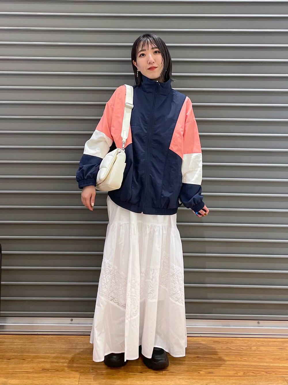 ホワイト系のショルダーバッグ、ブルー系のブルゾン、ホワイト系のワンピースを着用したレディースの春コーディネートの3枚目の写真