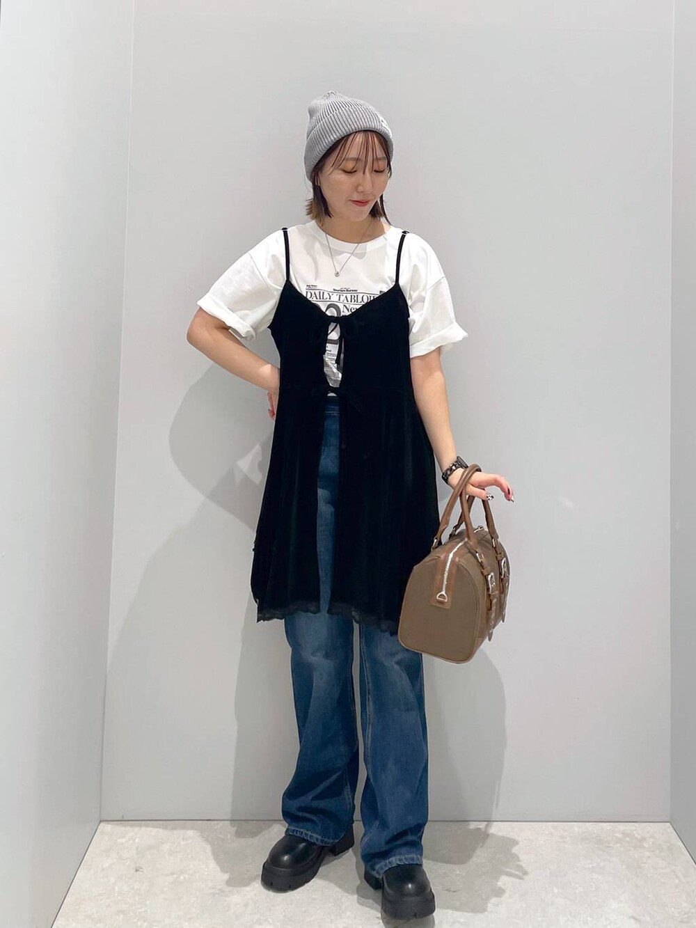 ブルー系のデニムパンツ、グリーン系のボストンバッグ、ホワイト系のTシャツ/カットソーを着用したレディースの秋コーディネートの3枚目の写真