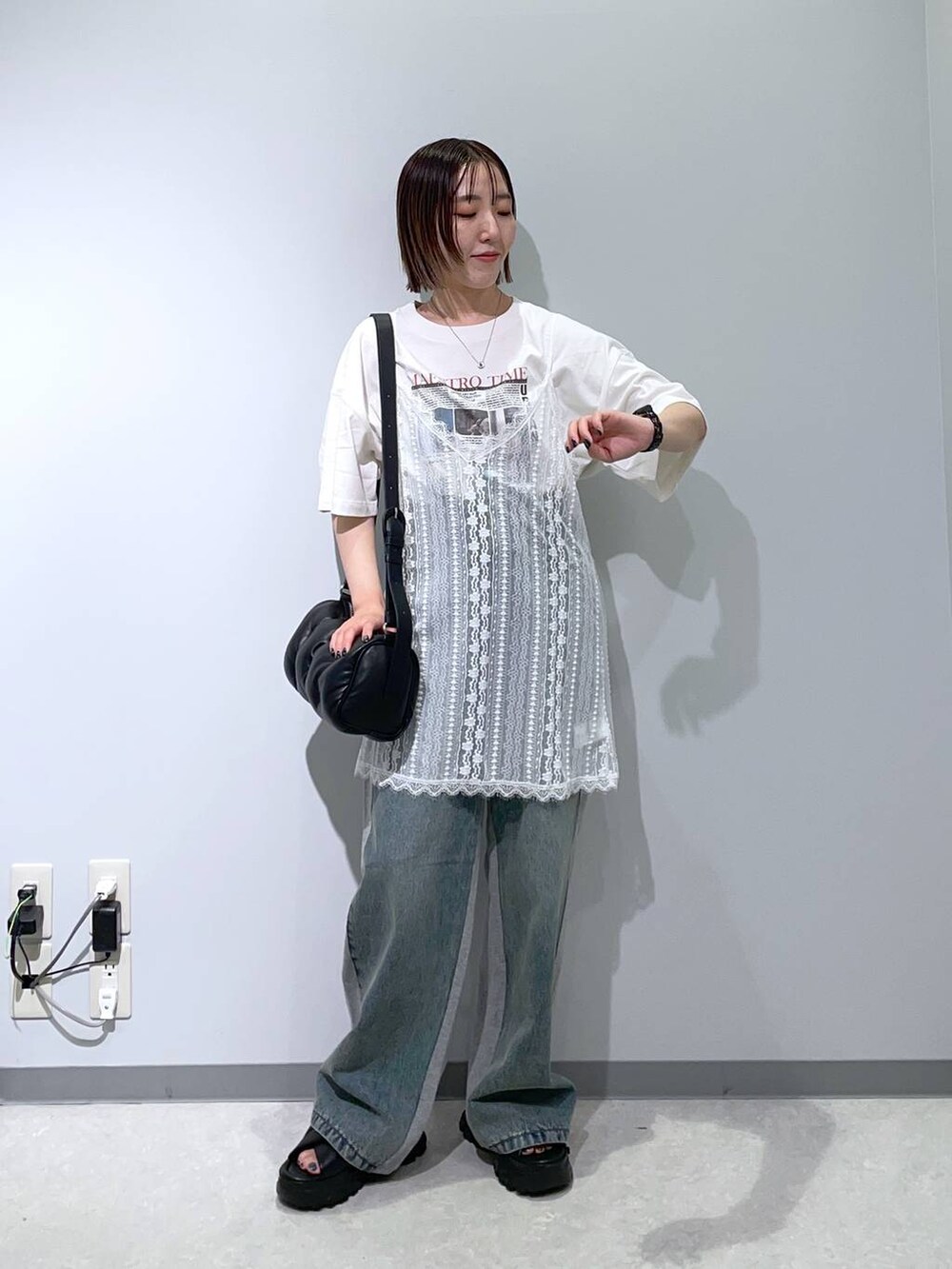 ブラック系のサンダル、ブラック系のショルダーバッグ、ホワイト系のその他トップスを着用したレディースの夏コーディネートの2枚目の写真