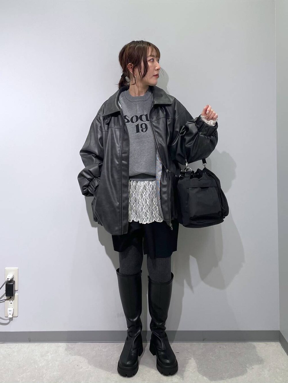 ブラック系のショルダーバッグ、ブラック系のブーツ、ブラック系のブルゾンを着用したレディースの冬コーディネートの5枚目の写真