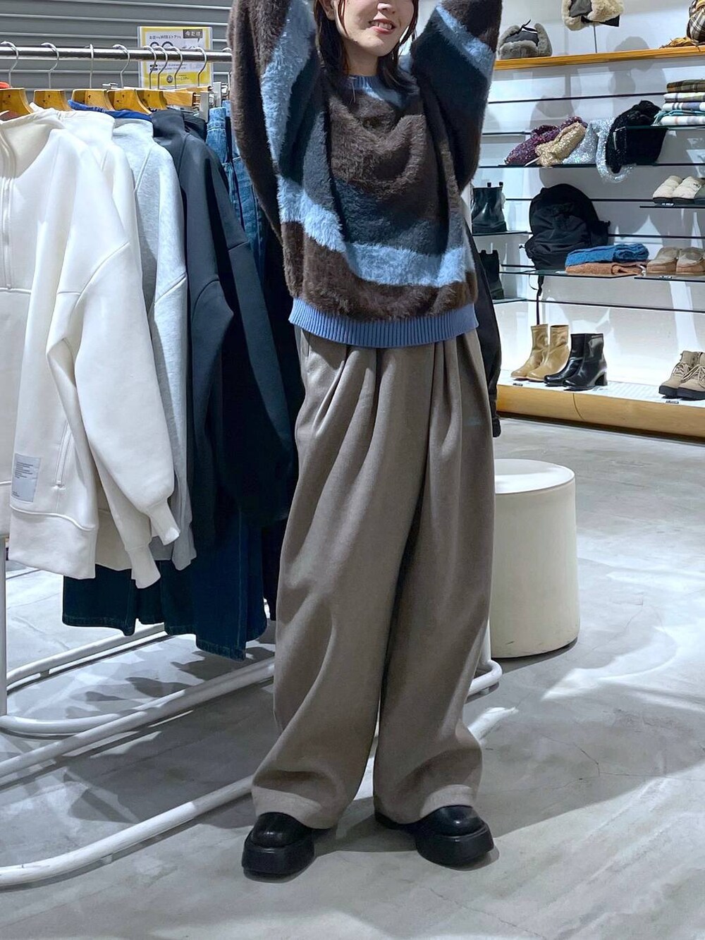 ブラック系のブーツ、ベージュ系のその他パンツ、ブルー系のニット/セーターを着用したレディースの秋コーディネートの2枚目の写真