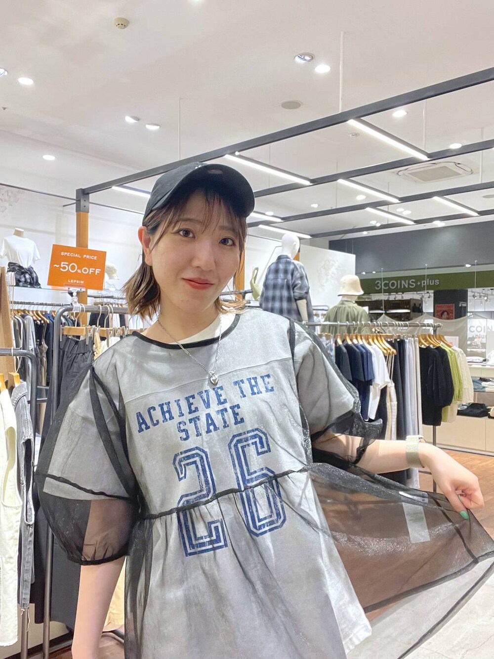 ホワイト系のTシャツ/カットソー、ブラック系のスカート、ブラック系のシャツ/ブラウスを着用したレディースの春コーディネートの3枚目の写真