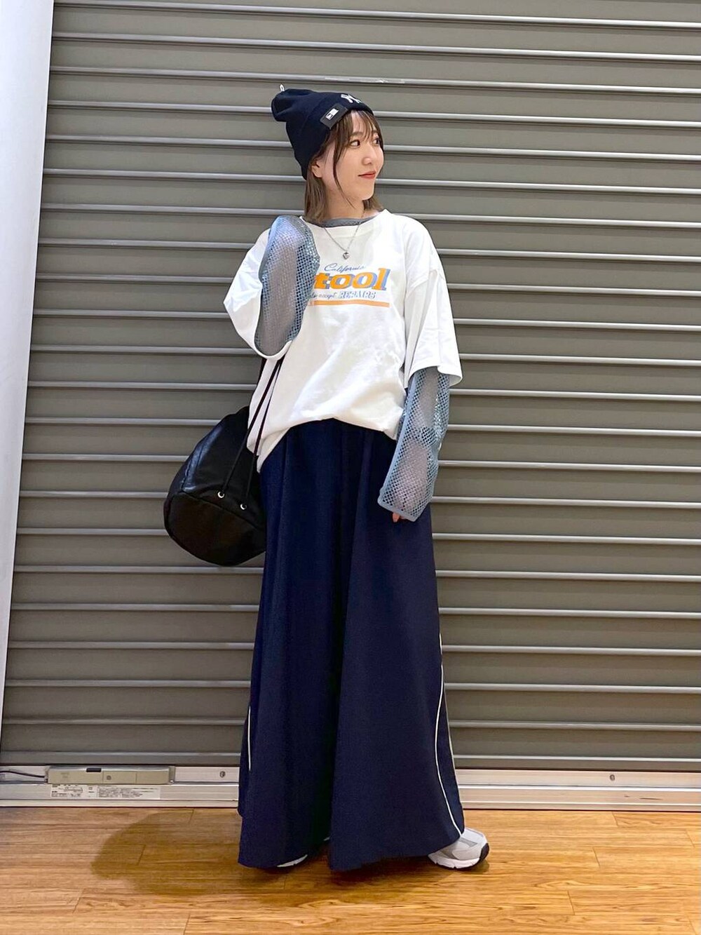 グレー系のスニーカー、ブラック系のショルダーバッグ、ブルー系のその他パンツを着用したレディースの春コーディネートの2枚目の写真