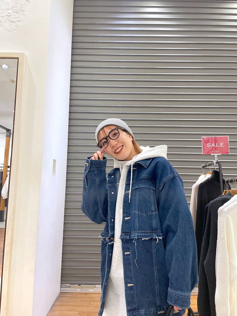 ブルー系のデニムジャケット、グレー系のスカート、ブラック系のショルダーバッグを着用したレディースの冬コーディネートの4枚目の写真