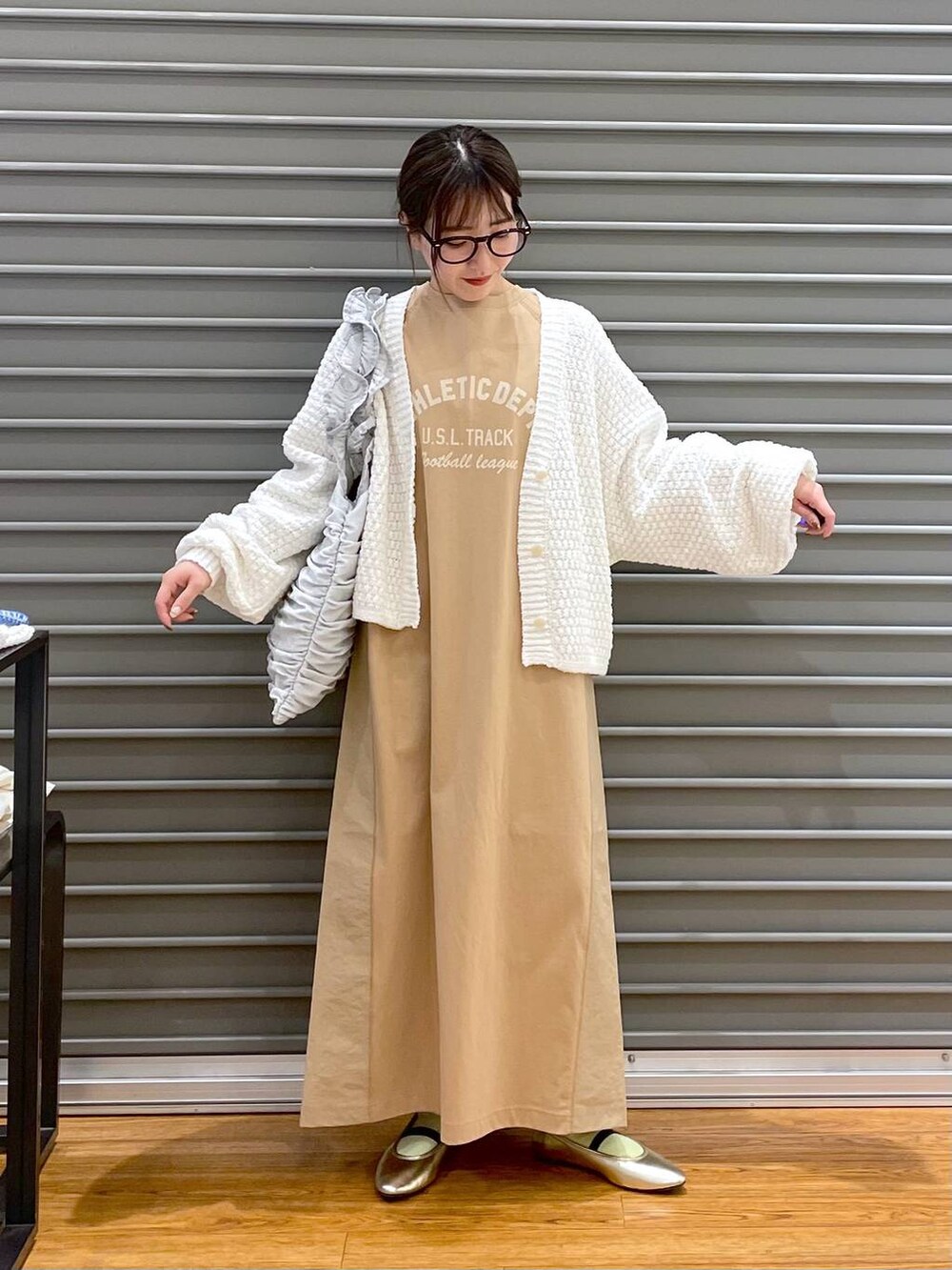 ゴールド系のバレエシューズ、ホワイト系のカーディガン/ボレロ、シルバー系のトートバッグを着用したレディースの春コーディネートの2枚目の写真