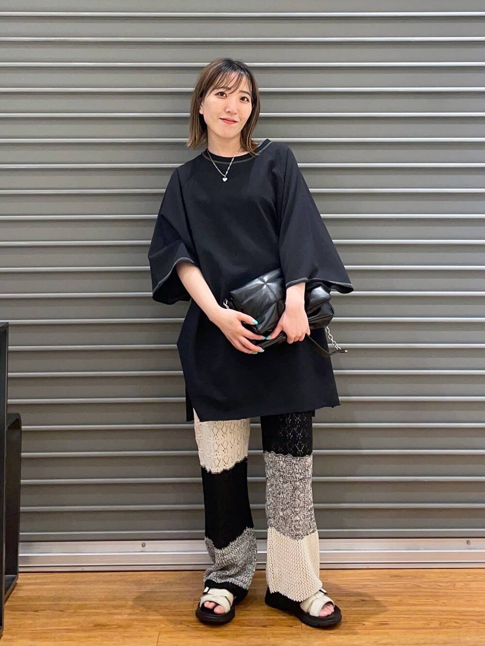 ブラック系のショルダーバッグ、グレー系のその他パンツ、ホワイト系のサンダルを着用したレディースの春コーディネートの2枚目の写真