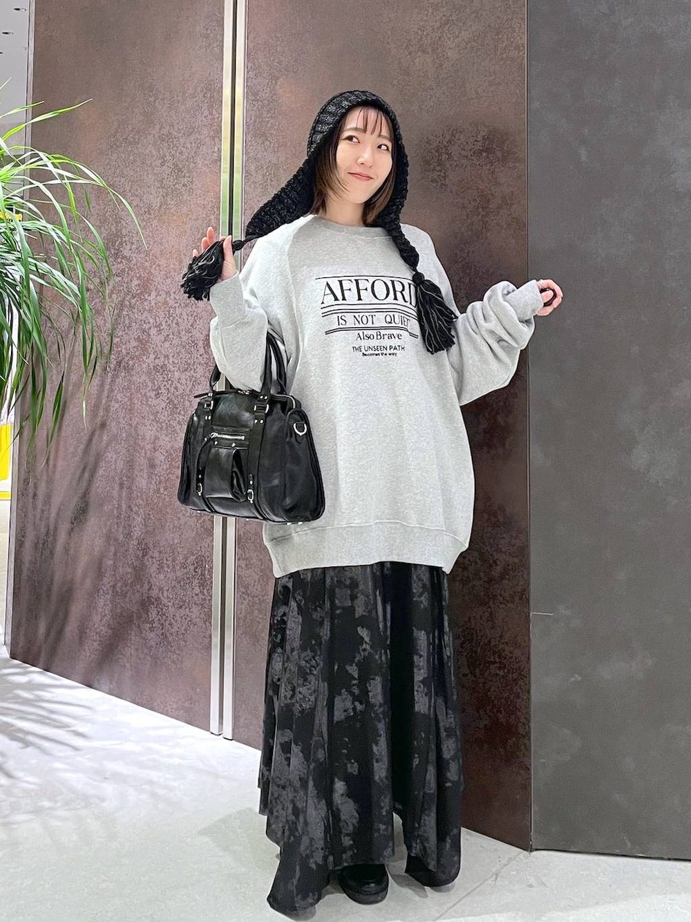 ブラック系のボストンバッグ、グレー系のスウェット、ブラック系のスカートを着用したレディースの秋コーディネートの3枚目の写真