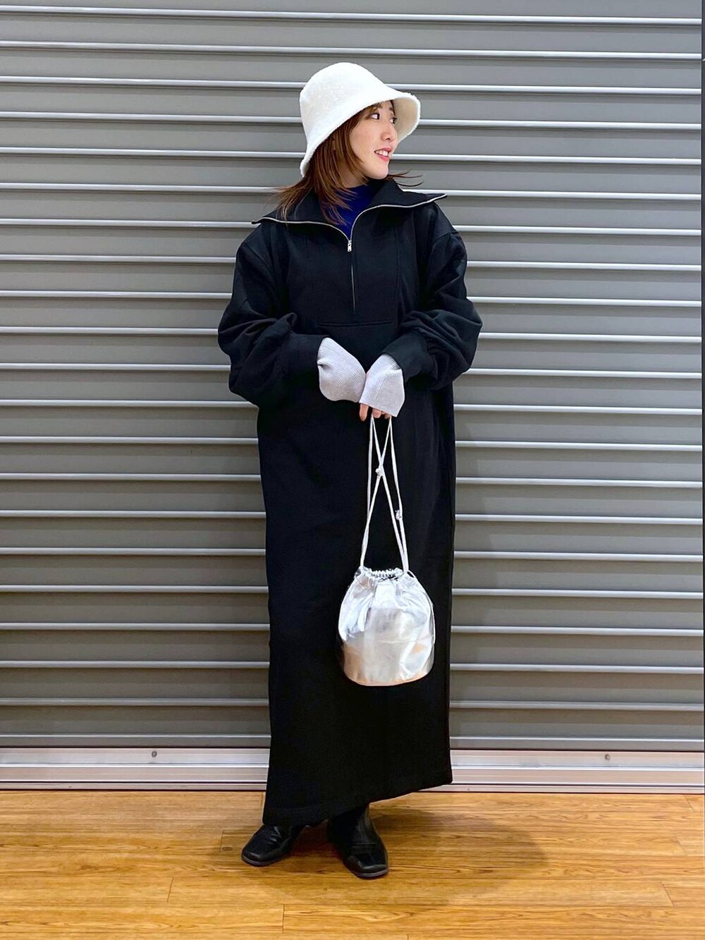 ブラック系のワンピース、シルバー系のショルダーバッグ、ブルー系のニット/セーターを着用したレディースの冬コーディネートの2枚目の写真