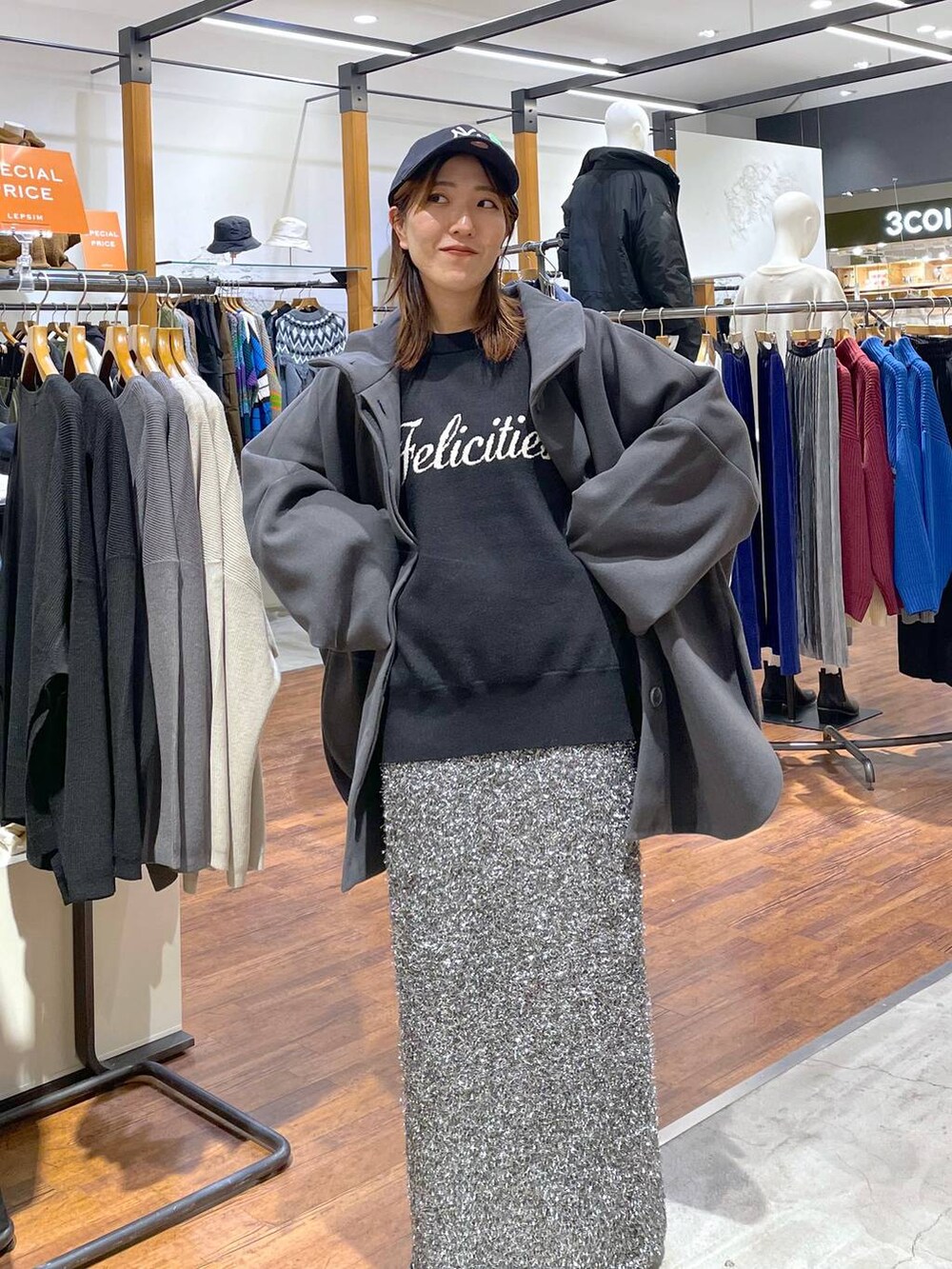 グレー系のポンチョ、ブラック系のニット/セーター、ブラック系のスカートを着用したレディースの冬コーディネートの2枚目の写真