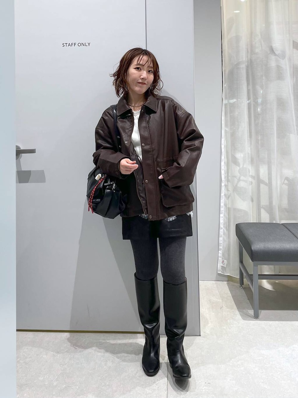 ブラック系のその他パンツ、ブラウン系のミリタリージャケット、ブラック系のボストンバッグを着用したレディースの春コーディネートの6枚目の写真