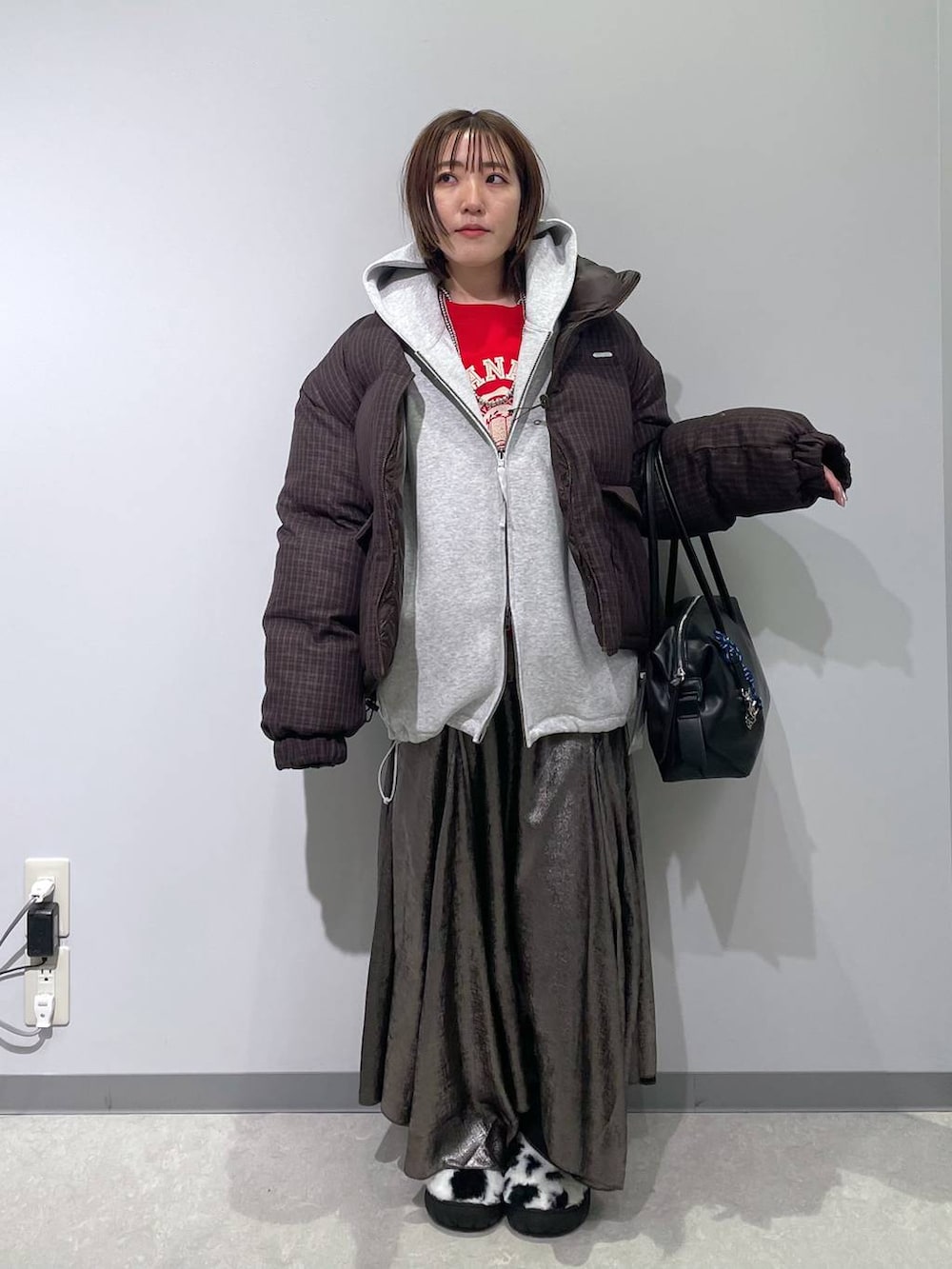 ホワイト系のスリッポン、ブラック系のボストンバッグ、ブラウン系のブルゾンを着用したレディースの冬コーディネートの4枚目の写真