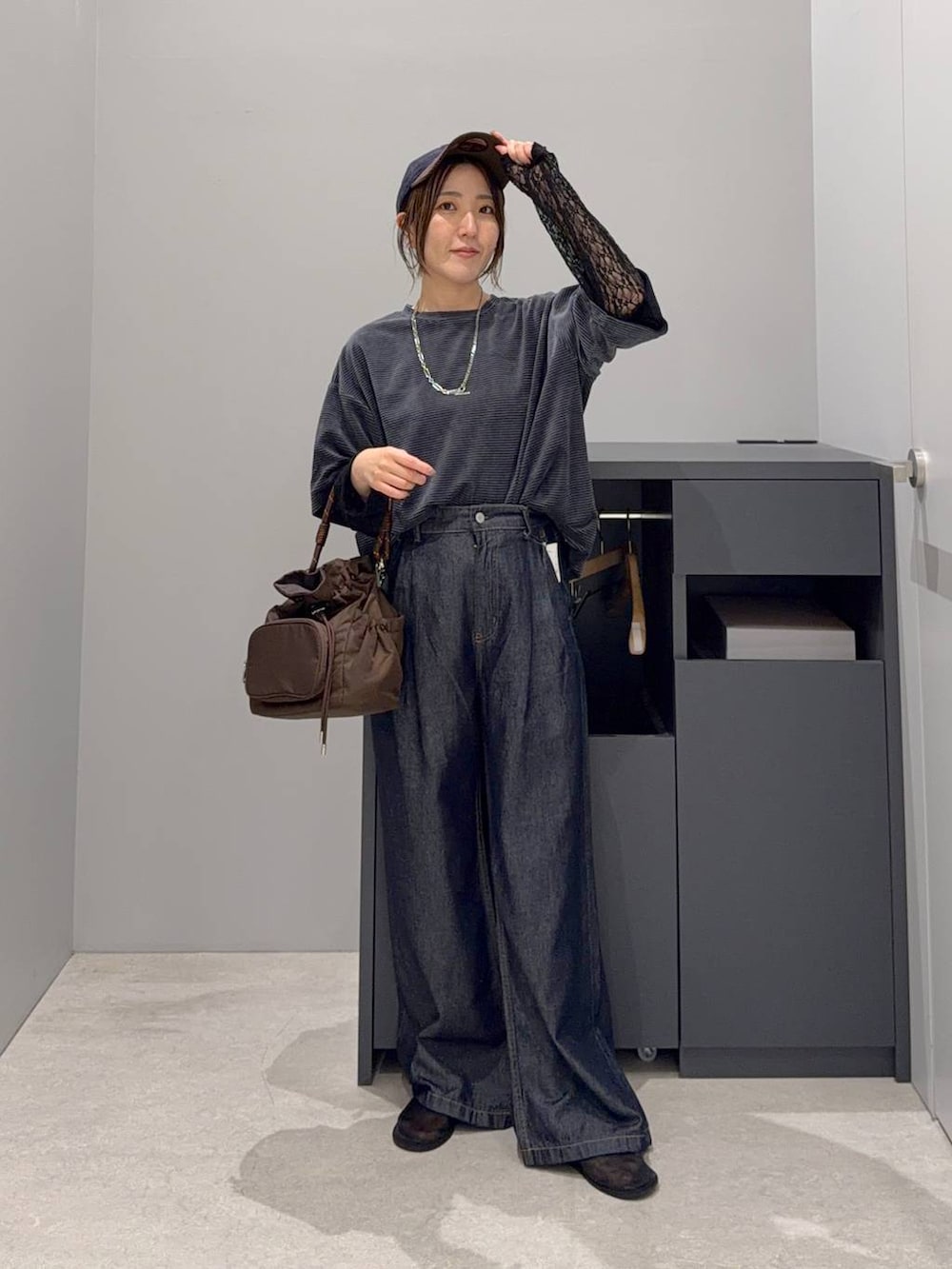 グリーン系のTシャツ/カットソー、ブラウン系のショルダーバッグ、ブルー系のデニムパンツを着用したレディースの夏コーディネートの3枚目の写真