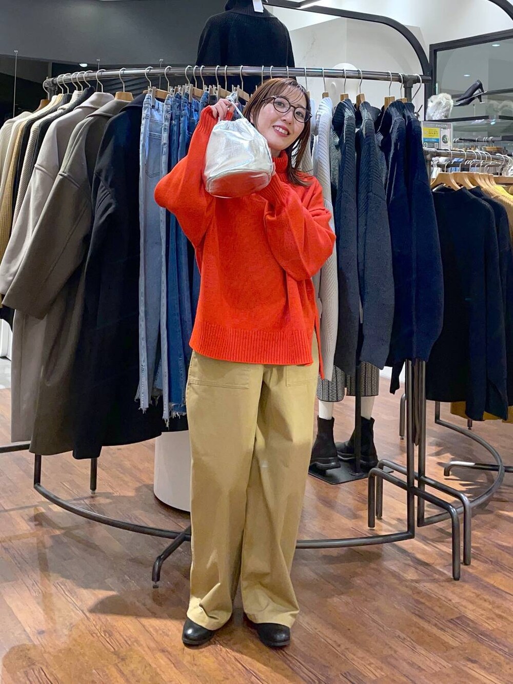 レッド系のニット/セーター、ブラウン系のブーツ、ベージュ系のその他パンツを着用したレディースの冬コーディネートの2枚目の写真