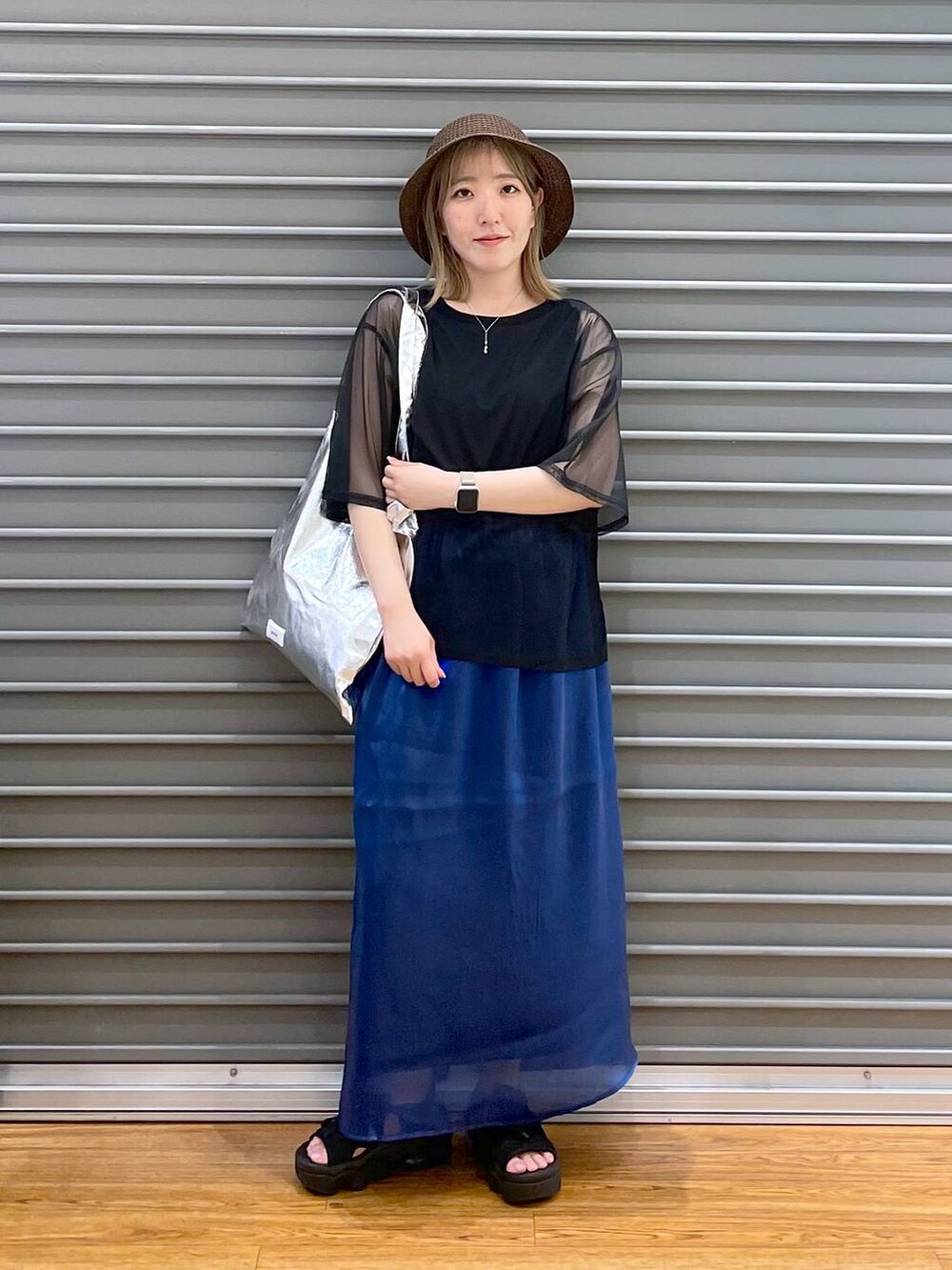 ブラック系のTシャツ/カットソー、シルバー系のトートバッグ、ブルー系のスカートを着用したレディースの春コーディネートの2枚目の写真