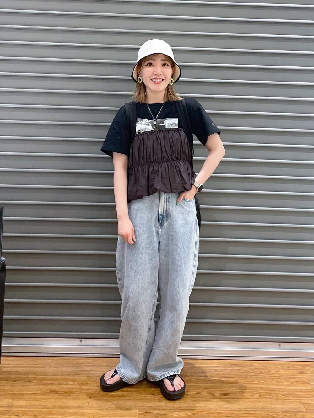 ブラウン系のシャツ/ブラウス、ブラック系のTシャツ/カットソー、ブルー系のデニムパンツを着用したレディースの春コーディネートの3枚目の写真