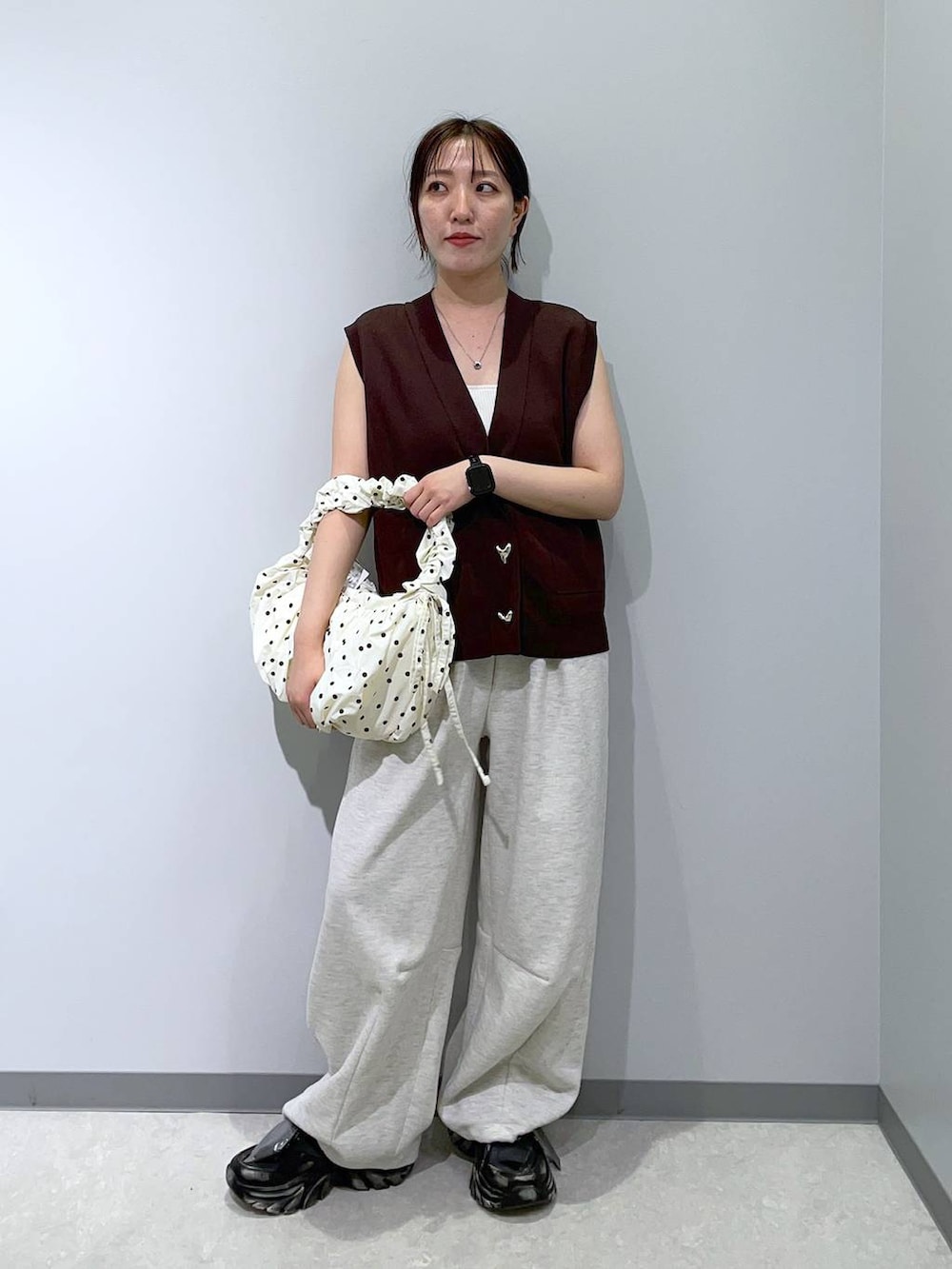 ブラック系のスニーカー、グレー系のスウェットパンツ、ブラウン系のベストを着用したレディースの夏コーディネートの3枚目の写真